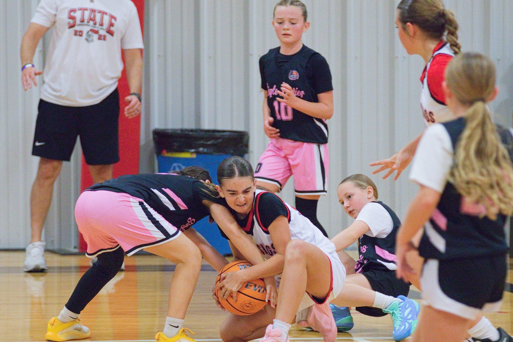 Players scrambling on the floor for a loose basketball