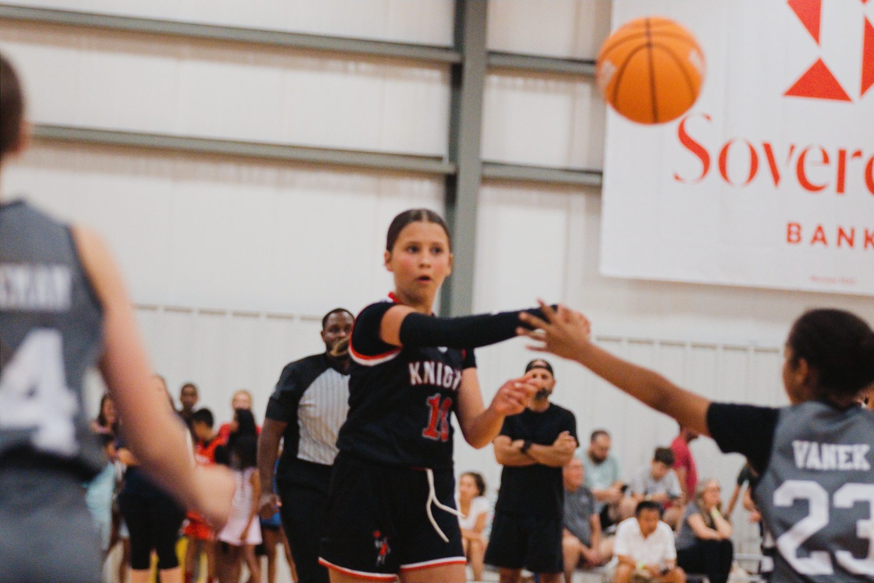 Basketball player defending as a teammate takes the ball up court