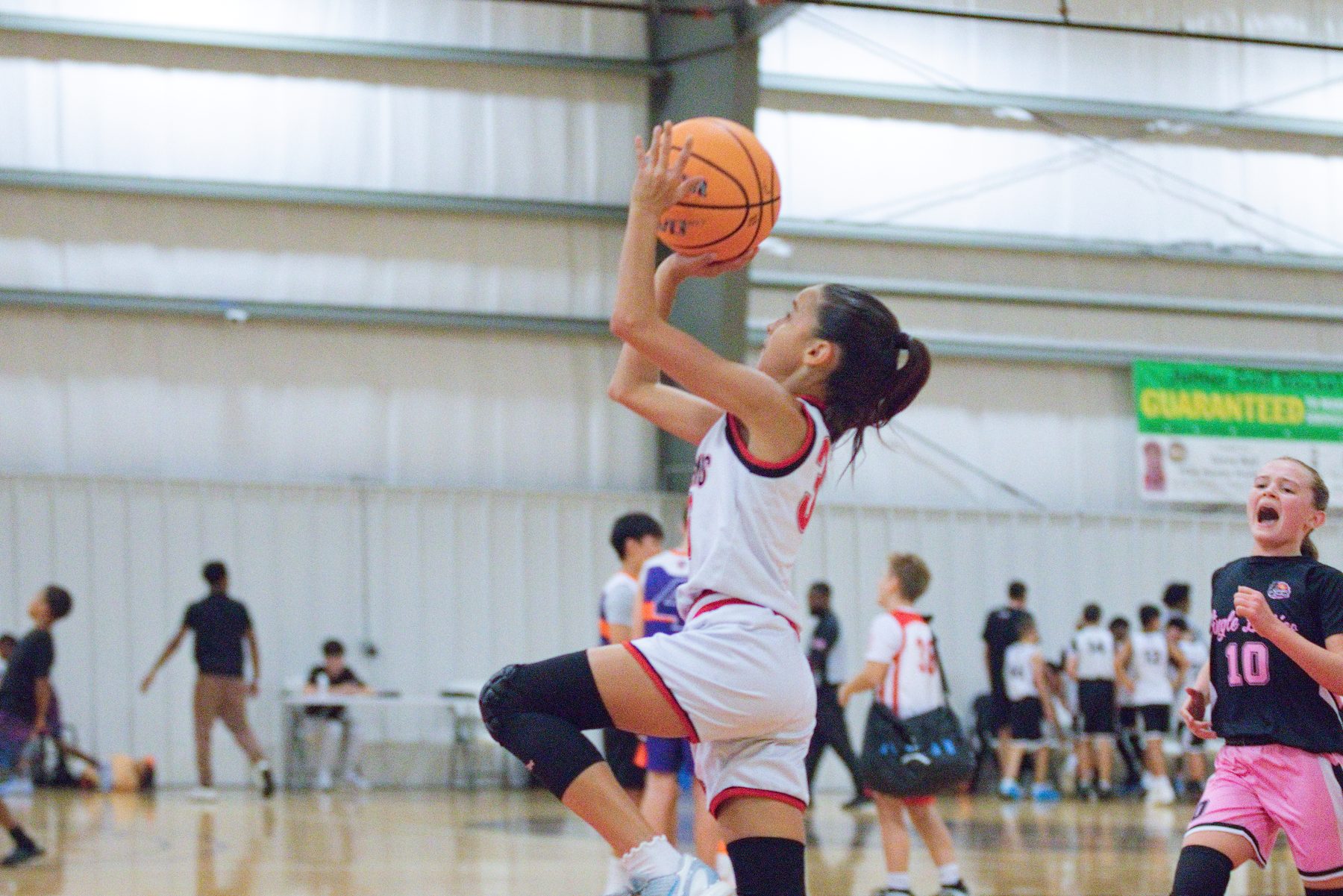 Basketball player rising for a jump shot in a crowded gym