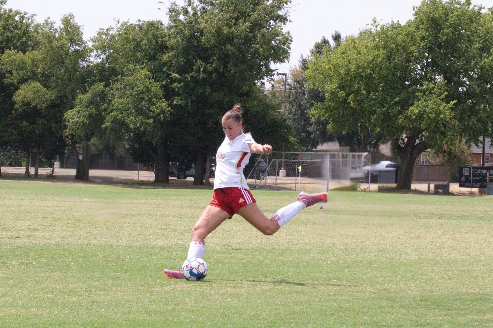 Youth soccer player striking the ball mid-kick during a match in Oklahoma City